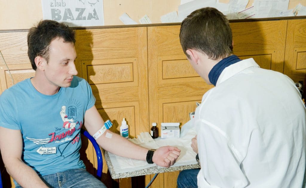 Young man receiving an HIV test while out at a gay nightclub, promoting safe and responsible practices within the LGBTQ+ community.