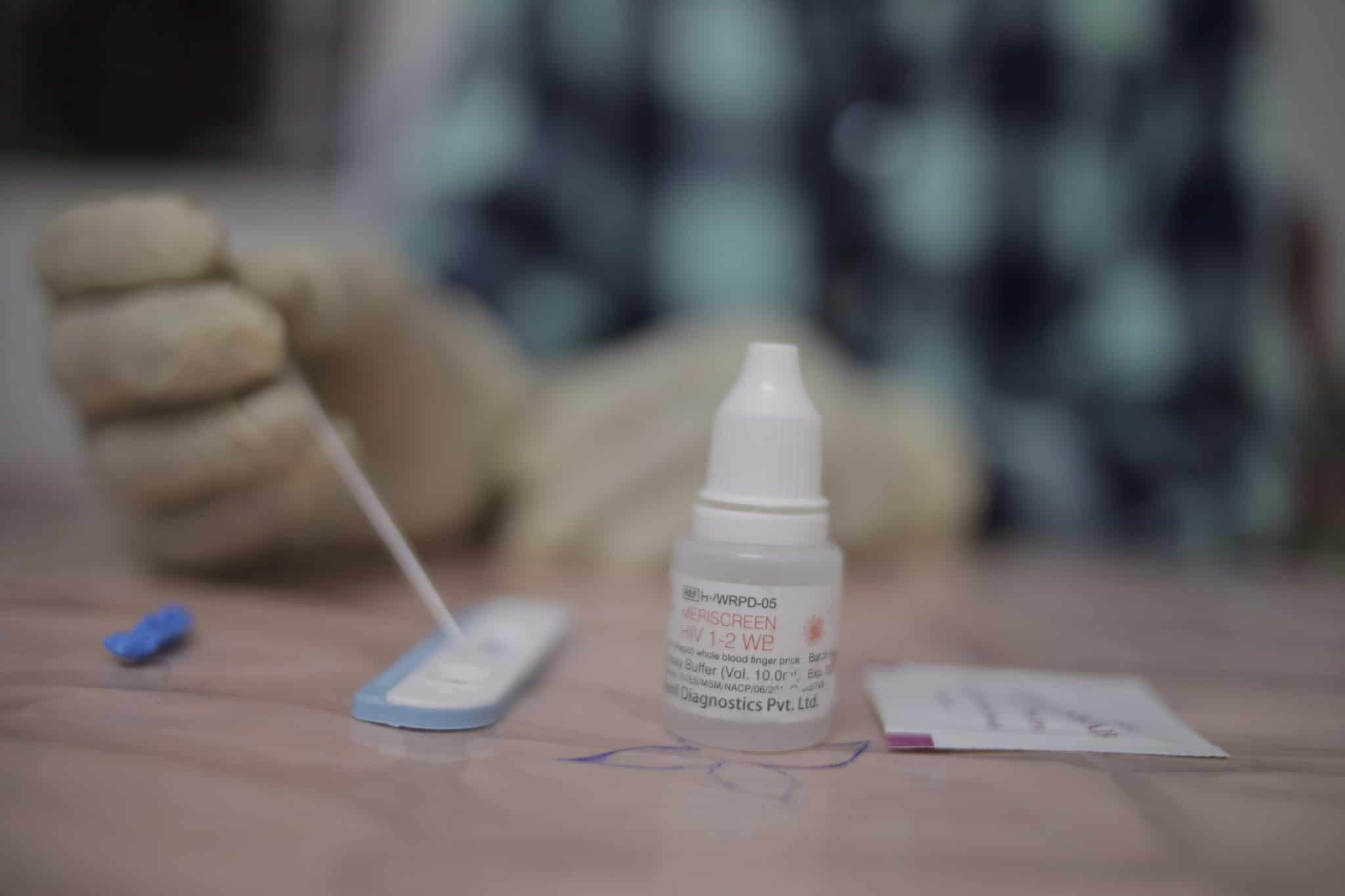 Close up image of a person's hands while they engage with an HIV self testing kit.