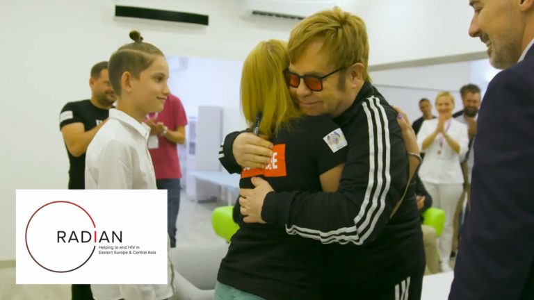 Elton John in an embrace while visiting the work of the Elton John AIDS Foundation in Eastern Europe and Central Asia.