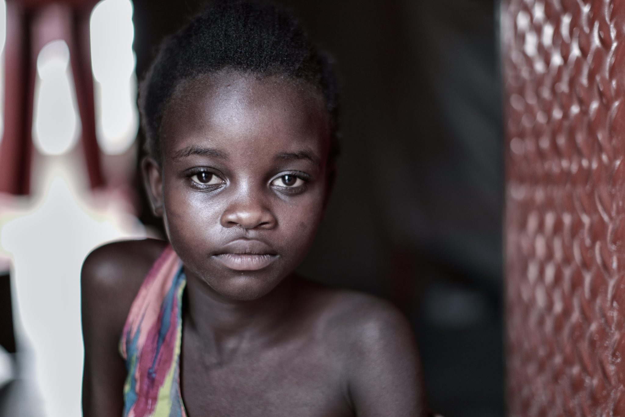 A young girl looking directly at the camera with a solemn expression.