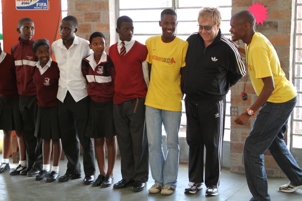 Elton John stands in a line with young people who are a part of a project funded by the Elton John AIDS Foundation.