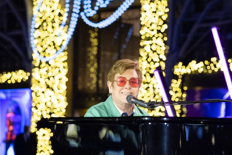 Elton John performing 'Your Song' on the piano in front of Saks Fifth Avenue for their holiday window unveiling event, in support of the Elton John AIDS Foundation