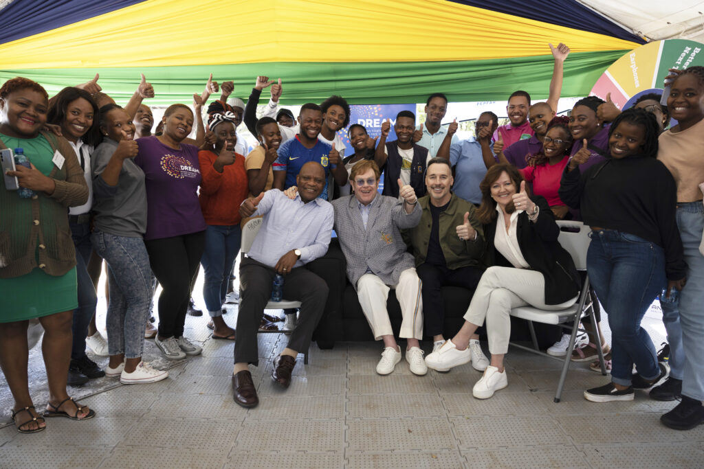 Elton John, David Furnish and Anne Aslett in a group photo with some of the young people who have benefitted from programmes supported by the Elton John AIDS Foundation.