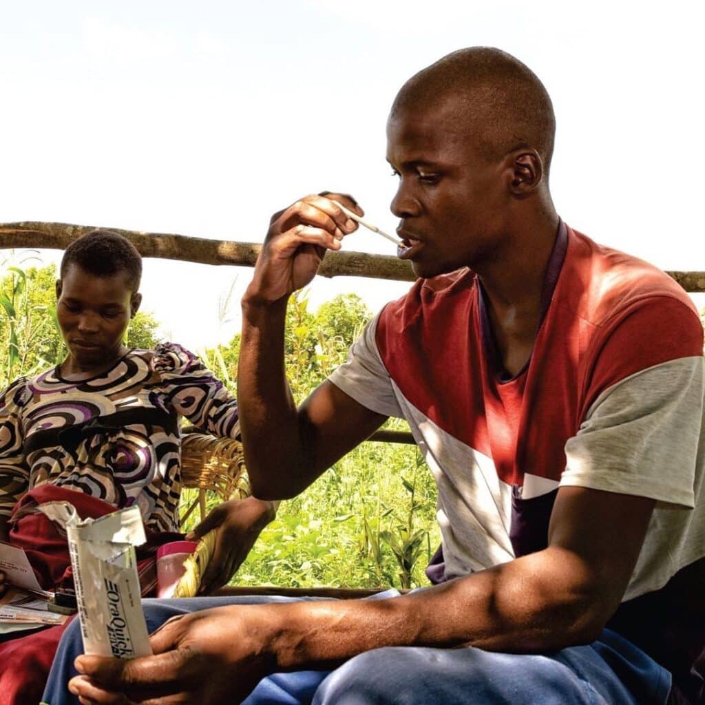 Man from Sub-Saharan Africa takes an oral HIV self-test to find out his HIV status.