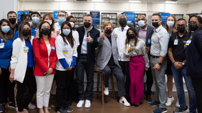 Elton John, David Furnish and Anne Aslett stand with the Walmart Heath team during a visit in Atlanta.