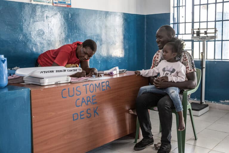 In the reception area of the Ayucha Health Centre in Kenya, Elvis sits with his daughter Katherine who he brought for a general check-up.