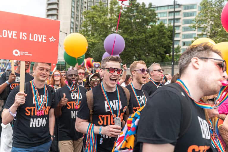 Elton John AIDS Foundation team at London Pride with a placard that reads 'Love is love'.
