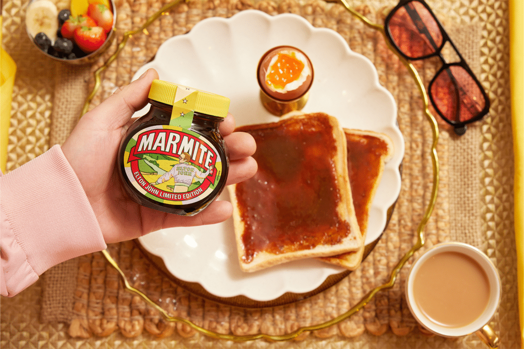 Breakfast scene with Elton John AIDS Foundation limited-edition Marmite jar, Marmite on toast, soft boiled egg and a cup of tea.