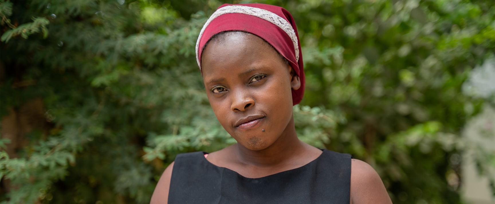 Girl wears headscarf and looks directly into the camera.