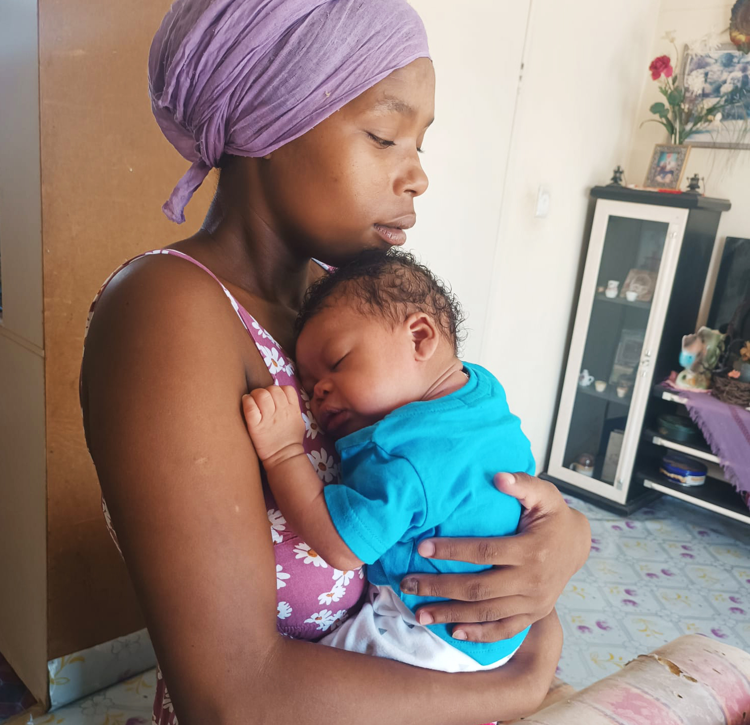 Mother holds her baby to her chest.
