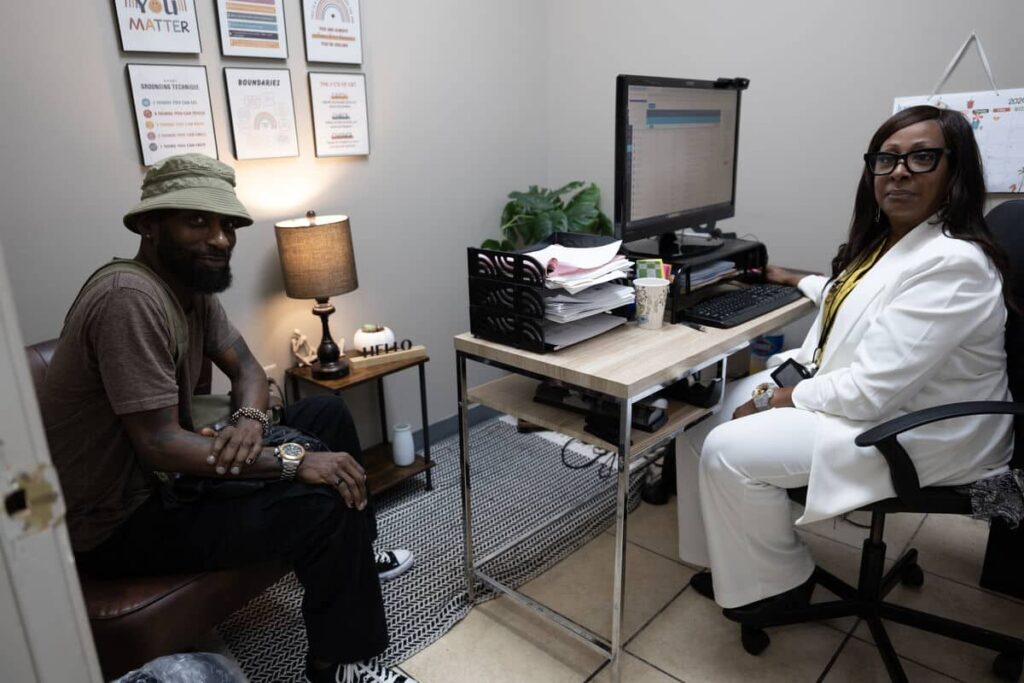 Ulysses sits with Lead Linkage ADAP Specialist from Georgia Harm Reduction Coalition in her office.