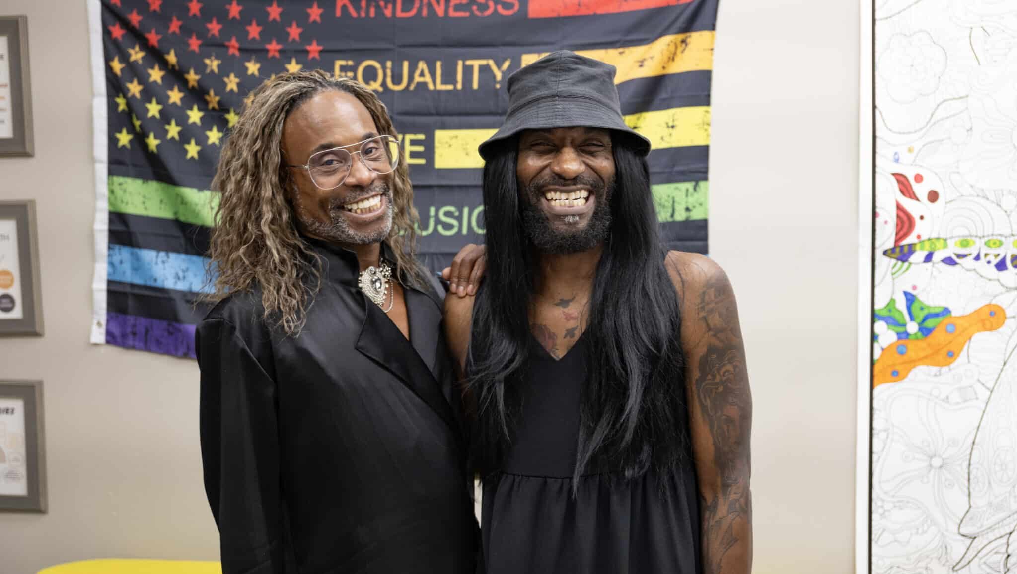 Ulysses stands alongside Billy Porter smiling.