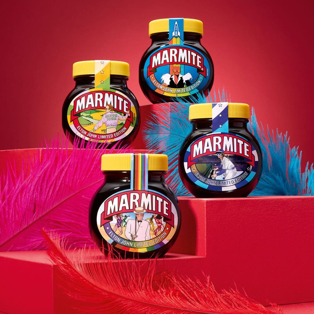 All four jars from the limited-edition Elton John Marmite jars are displayed against a red background.